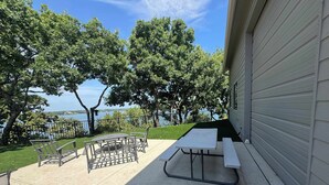 An outdoor patio with a picnic table and chairs, a small round table, and a metal chair. - 4-BD/2-BA Southern Retreat with Waterfront Patio (Gainesville)