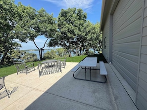An outdoor patio with a picnic table and chairs, a small round table, and a metal chair. - 4-BD/2-BA Southern Retreat with Waterfront Patio (Gainesville)