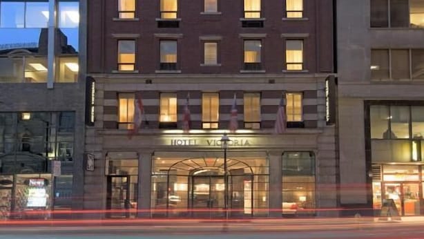 A multi-story hotel with a classic facade, a prominent entrance, and a clear view of the street. - Classic Yonge Stay (Toronto)