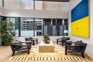 A modern lobby with a checkered floor, a central plant, and a large window with a view of a building. - Luxury Miami 1BR Apt, Pool & Beach Access for 4 (Miami)