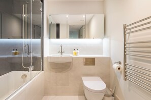 Ein modernes Badezimmer mit Duschkabine, Waschbecken und Toilette.