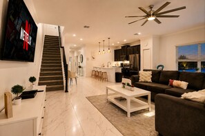 A modern living room with a staircase, a kitchen, and a dining area. - 5-bedroom 2 MINUTE WALK TO RESORT (Davenport)