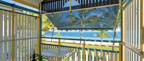 Un área de estar techada al aire libre con vistas a la playa y el océano.