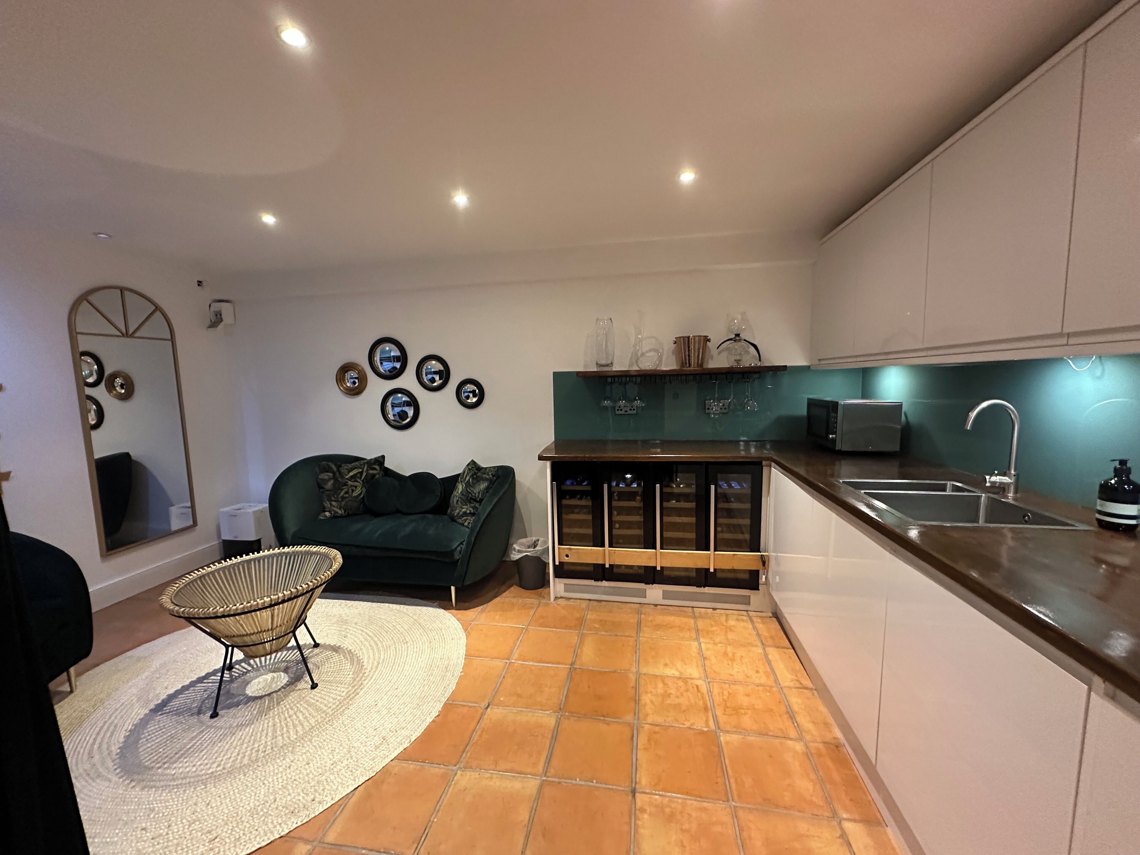A compact living space with a kitchenette, a sofa, a dining area, and a small bar area.