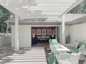A covered outdoor seating area with a white pergola, a dining table, and chairs. - Boutique Riverside Retreat (Seaford)