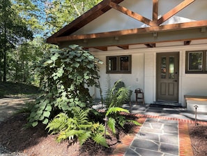 A house with a porch, a green chair, and a bench. - Boutique Riverside Retreat (Seaford)