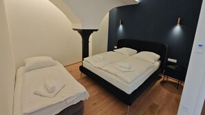 Ein Schlafzimmer mit einem Bett, einem Nachttisch, einer Lampe und einer gewölbten Wand.