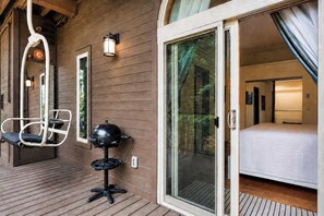 A hotel room with a sliding glass door, a bed, a small table with a grill, and a chair. - Frisco Retreat | Creekside • Unbeatable Location (Frisco)