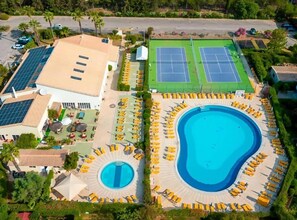 A resort with a large swimming pool, tennis courts, and a covered area with seating. - Heated Indoor Pool, Jacuzzi & Tennis | Ground Floor 2BR Oasis Parque Portimao (Portimão)