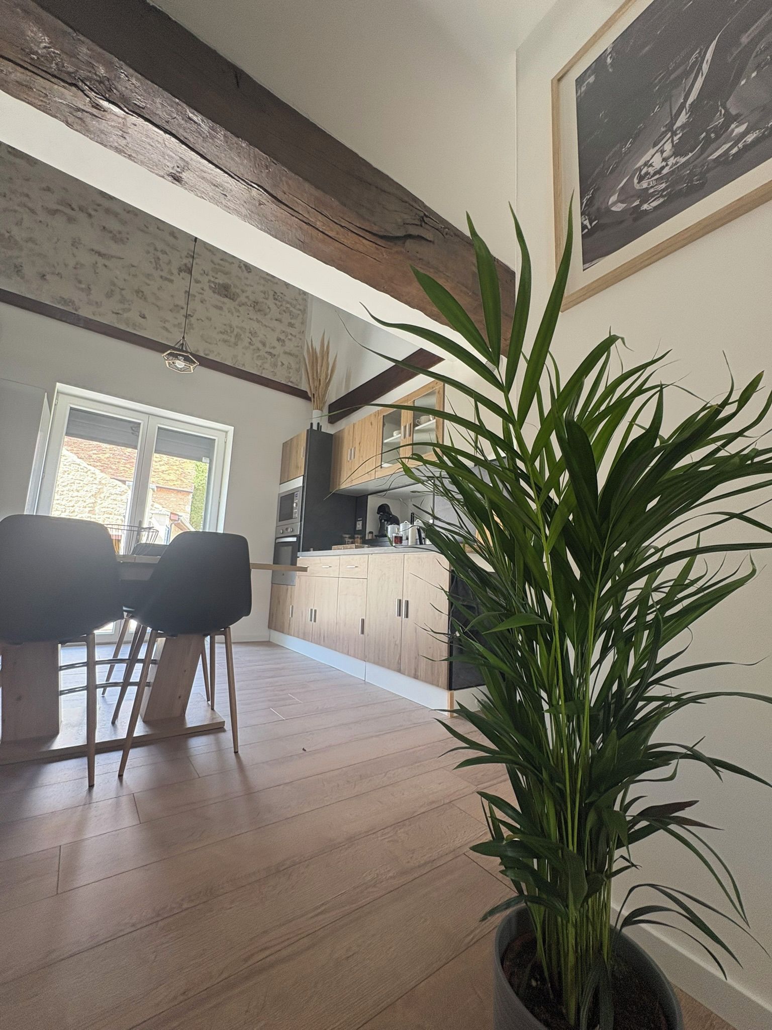 Une cuisine moderne avec des meubles en bois et un coin repas comprenant une table et des chaises.