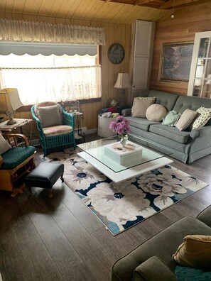Una sala de estar acogedora con sofá, sillón, mesita de centro y alfombra.