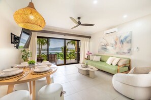Ein modernes Wohnzimmer mit Essbereich, einem grünen Sofa und Blick ins Freie.
