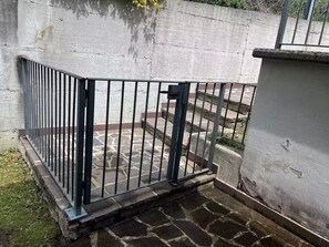 Un espacio exterior amurallado con suelo de piedra y pared de concreto.