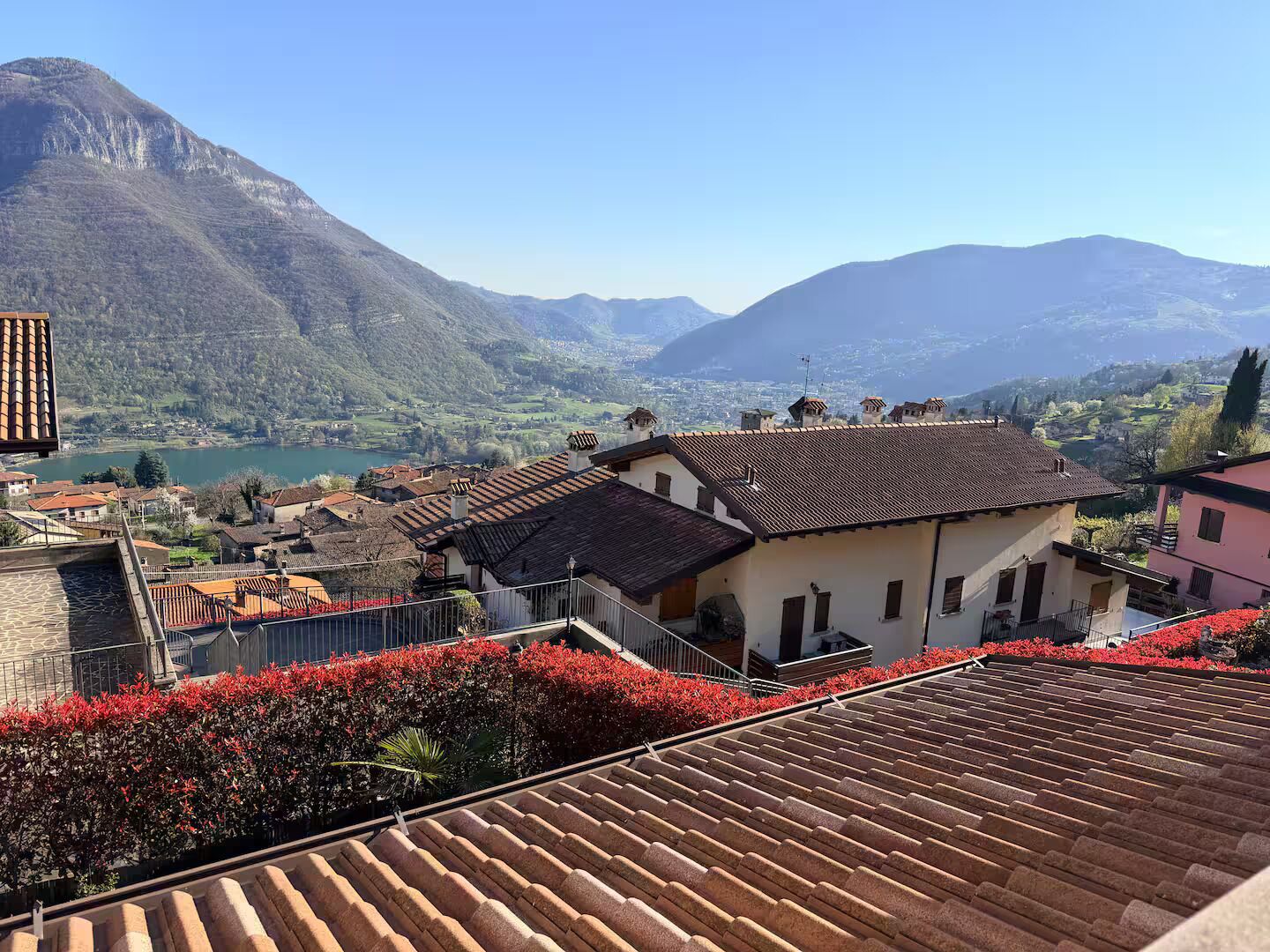 Quartiere residenziale con case a schiera, una montagna sullo sfondo e una distesa d'acqua.