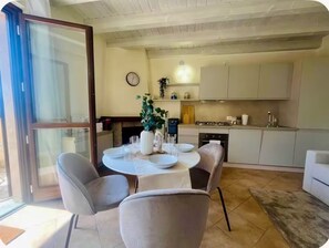 Un comedor con una mesa redonda, sillas y un florero con flores.