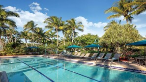 A swimming pool with lounge chairs and umbrellas, surrounded by palm trees. - Bonita Springs 1BR Villa at Coconut Cove Near Gulf Beaches & Naples (Bonita Springs)