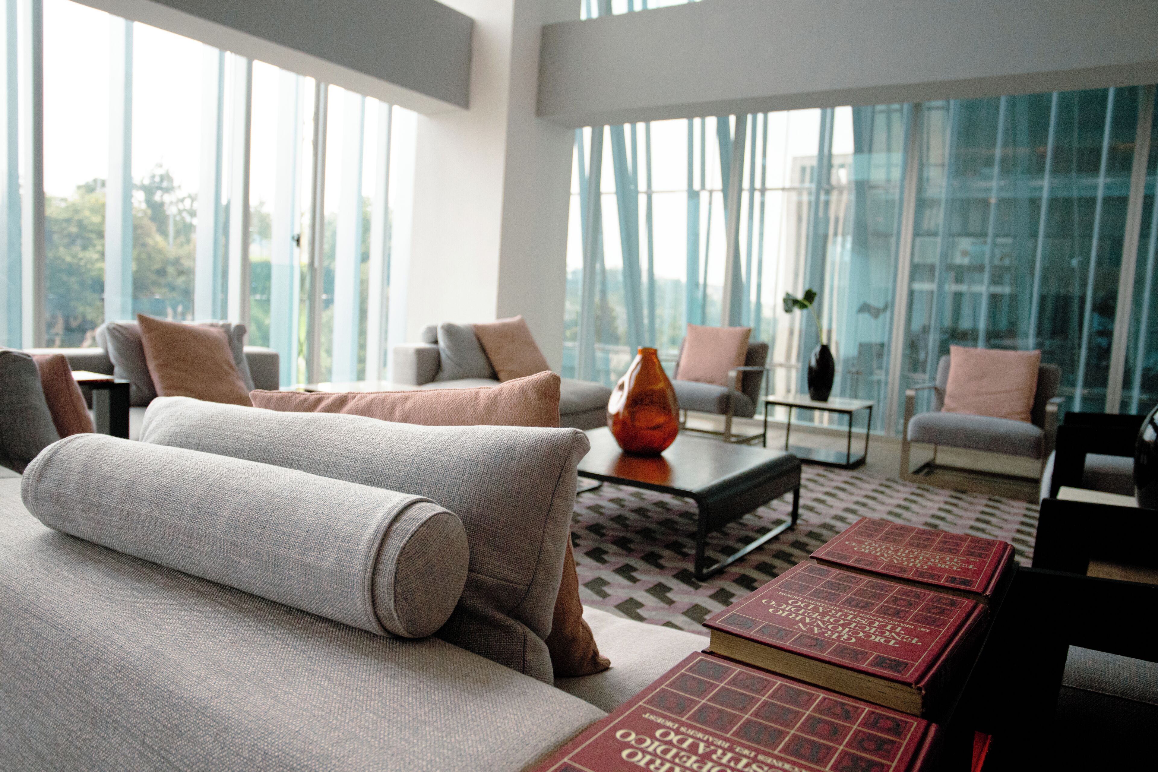 Una sala de estar moderna con un sofá, sillones, una mesa de centro y libros.