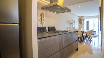 Una cocina moderna con estufa integrada, campana de acero inoxidable y un amplio ventanal que proporciona luz natural.