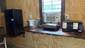A kitchenette with a refrigerator, a stove, and a microwave.