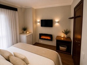 A bedroom with a bed, a wall-mounted TV, a fireplace, and a door. - Luxury in the Castle: Mountain duplex with complete leisure facilities. (Campos do Jordão)