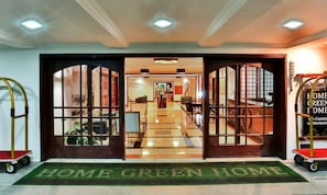 A hotel entrance with a green mat reading 'HOME GREEN HOME' and a sign on the right. - Luxury in the Castle: Mountain duplex with complete leisure facilities. (Campos do Jordão)