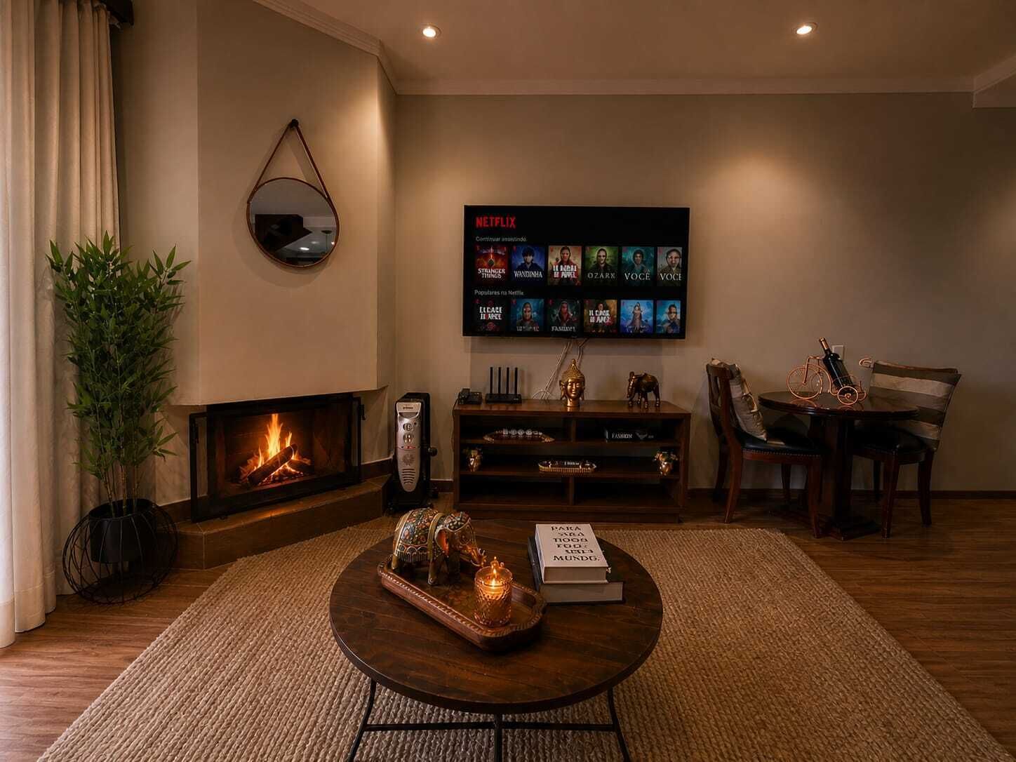 Ein gemütliches Wohnzimmer mit Kamin, Couchtisch mit Dekoration, Bücherregal und Wand-Fernseher, der Inhalte von Netflix zeigt.