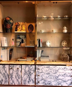 Una teca con libri, una cornice e oggetti decorativi.