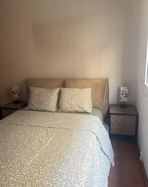 Ein Schlafzimmer mit einem Bett, zwei Nachttischen und einem Fenster.