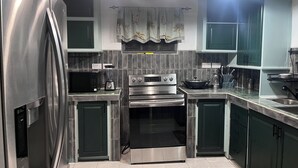 A modern kitchen with stainless steel appliances, a built-in oven, and a microwave.