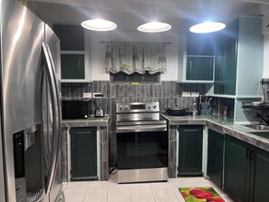 A modern kitchen with stainless steel appliances, a built-in oven, and a microwave.