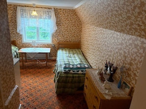 A bedroom with a bed, a dresser, a table with a lamp, and a window with curtains. - 4 Person Holiday Home in Hassela (Hassela)