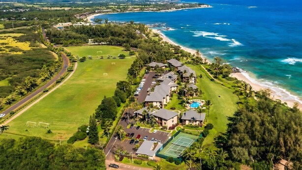 An aerial view of a coastal property with a tennis court, a swimming pool, and a beach. - Breezy 4BR, 2 Condos for 12 at Kaha Lani, Lihue! (Lihue)