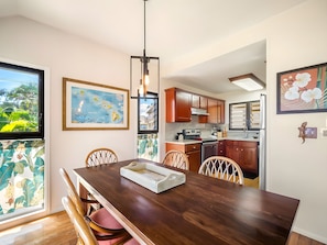 A dining area with a wooden table, chairs, and a map on the wall.