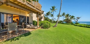 A beachfront property with a pool, lounge chairs, and a view of the ocean. - Breezy 4BR, 2 Condos for 12 at Kaha Lani, Lihue! (Lihue)
