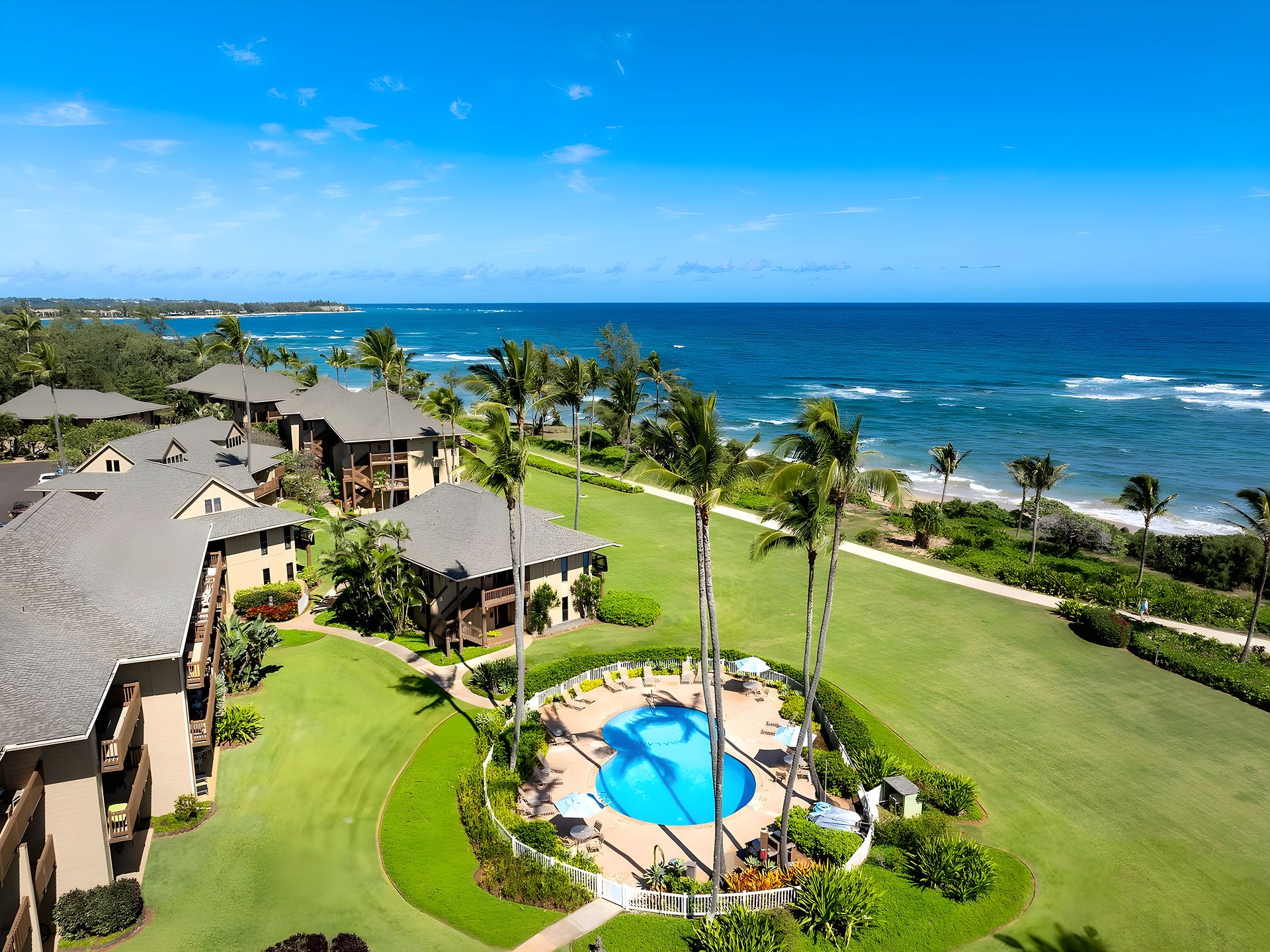 Un resort con piscina, vista a la playa y varias edificaciones.