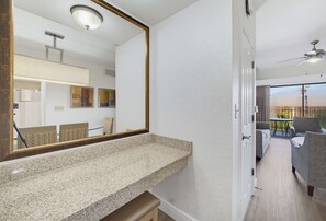 A modern interior with a kitchen counter, a large mirror, and a dining area with chairs. - 2B Resort Condo w/ Pool View 7 minutes to Disney (Orlando)
