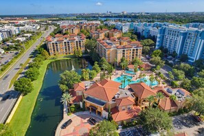 A residential area with a river, a swimming pool, and multiple apartment buildings. - Floridays 505D: 2BR for 6, Heated Pools, Free Parking & No Resort Fees (Orlando)