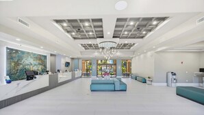 En rymlig entréhall med en receptionsdisk, en sittgrupp och utsikt över omgivningarna.