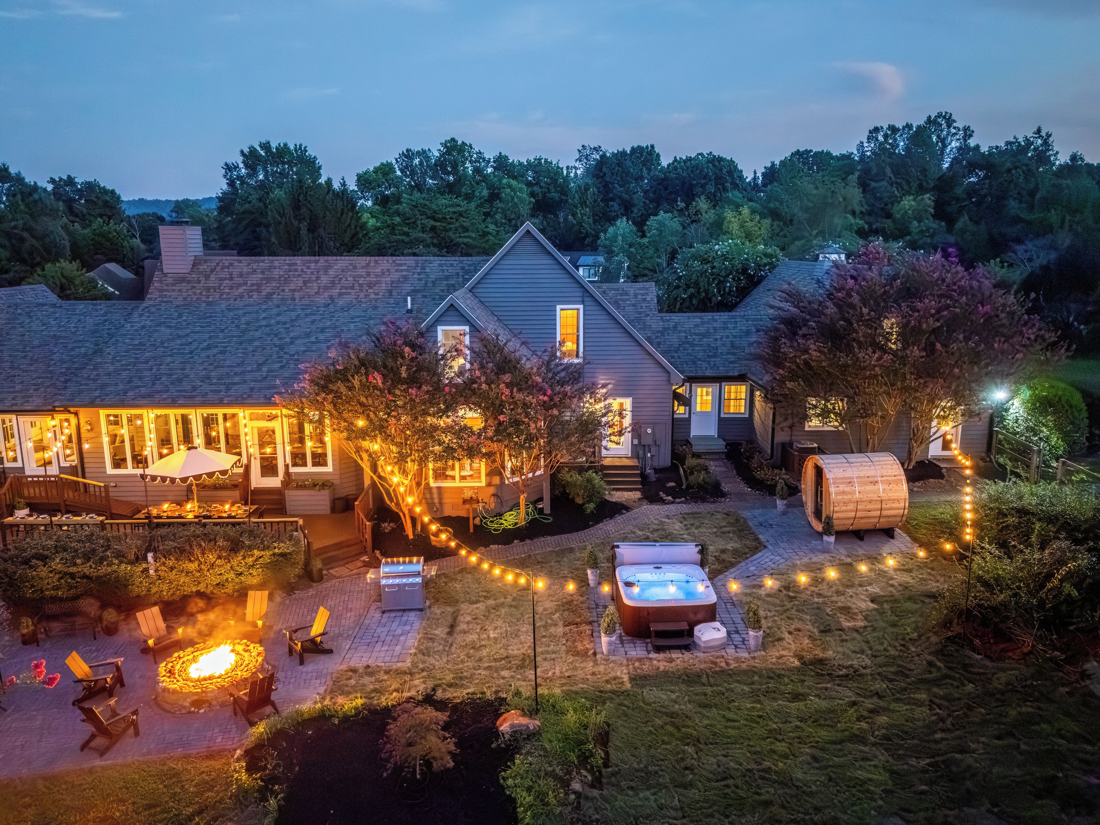 A residential property with a patio area, outdoor seating, a hot tub, and a fire pit.