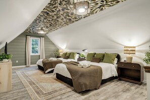 Una camera da letto con due letti, una finestra, un soffitto decorato con motivi a foglia e un comodino con una lampada.