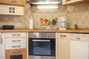 A kitchen with a built-in oven, a coffee maker, and a Bosch dishwasher. - Cozy family home with pool near the beach 
Afantou (Αφάντου)