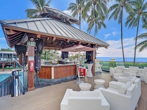 A beachside bar with white wicker furniture and a pool in the background. - Spacious 2BR Resort-Style Apartment with Ocean Views 504 (Miami Beach)