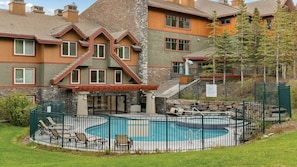 A residential building with a pool, outdoor seating, and a stone facade. - 2BR Suite at WorldMark Canmore-Banff Near Banff National Park & Skiing (Canmore)