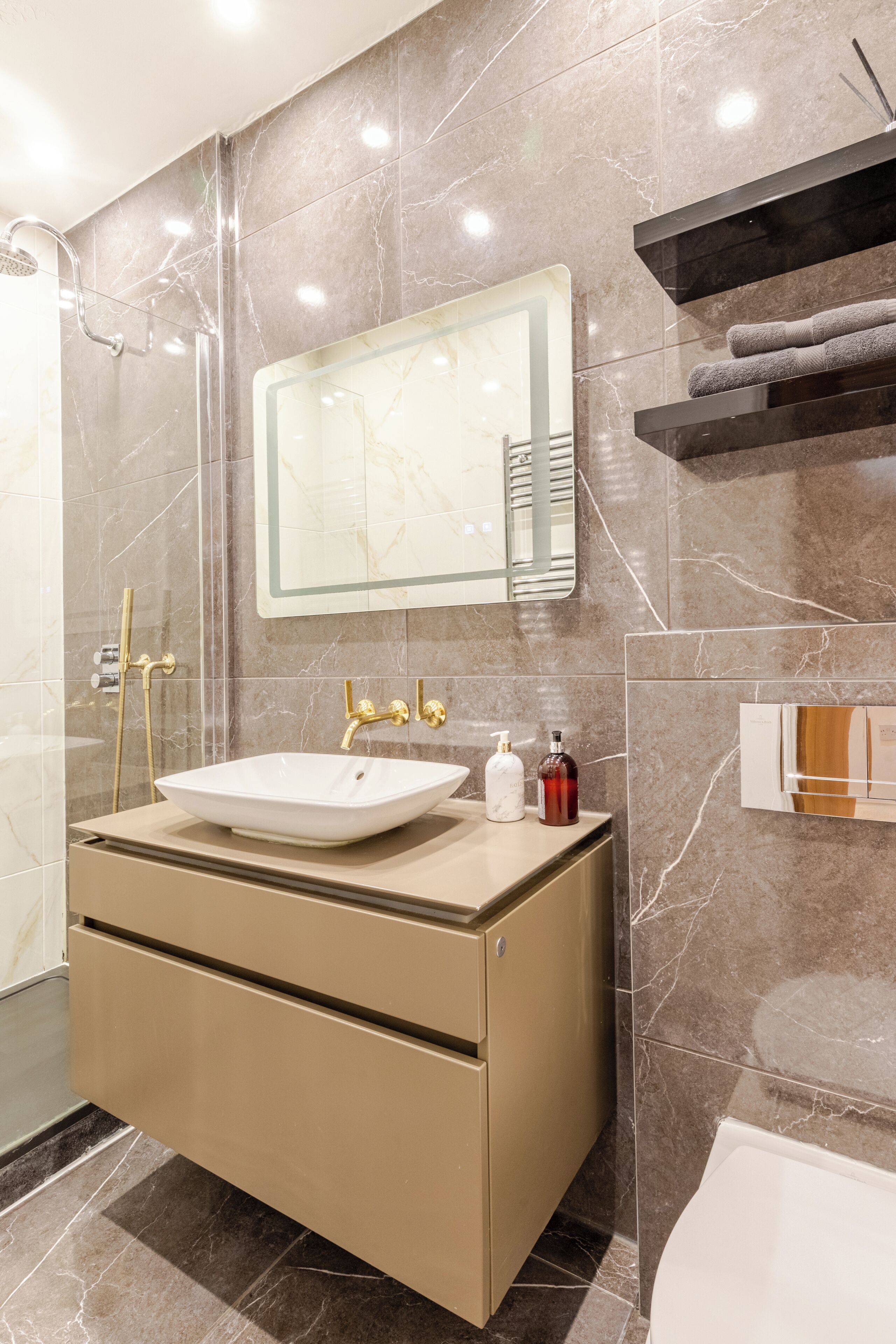 Een moderne badkamer met een grote spiegel, een wastafel en een douche.