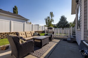 An outdoor patio with a sofa set, a coffee table, and a dining table. - Ogden Adventure Hub-Hike, bike, ski! Sleeps 7, 5 bedrooms, 3.5 bath home. (South Ogden)