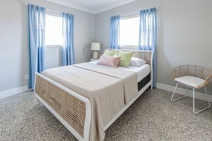 A bedroom with a bed, a bedside table, a lamp, and a chair. - Central getaway for exploring Bradenton and Sarasota with ease (Bradenton)
