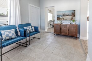 A living area with a sofa set, a wooden cabinet, and a dining table. - Central getaway for exploring Bradenton and Sarasota with ease (Bradenton)