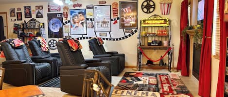 Ein Heimkinozimmer mit Deckenventilator, Popcornmaschine und einer Snackbar.