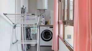 A laundry room with a washing machine, dryer, and a drying rack. - Designer Apart •High Floor Fast WiFi, Sagrada (Barcelona)