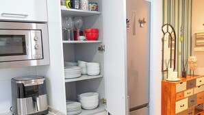 A compact kitchen with a built-in oven, a coffee maker, and a refrigerator with a freezer. - Designer Apart •High Floor Fast WiFi, Sagrada (Barcelona)